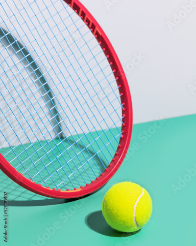Tennis composition with red tennis racket and yellow, tennis ball on a blue background. Tennis competition. Selective focus, closeup © KRISTINA KUPTSEVICH