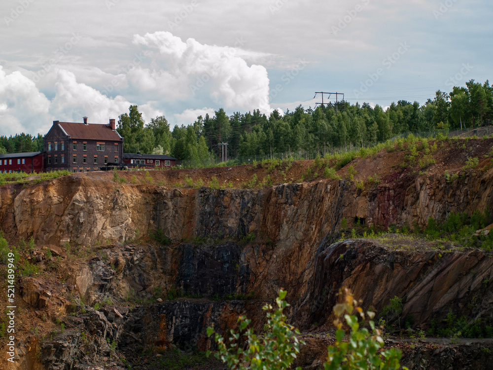 Falun Copper Mine the World Heritage with orange mountain visible and tourist spot in background.