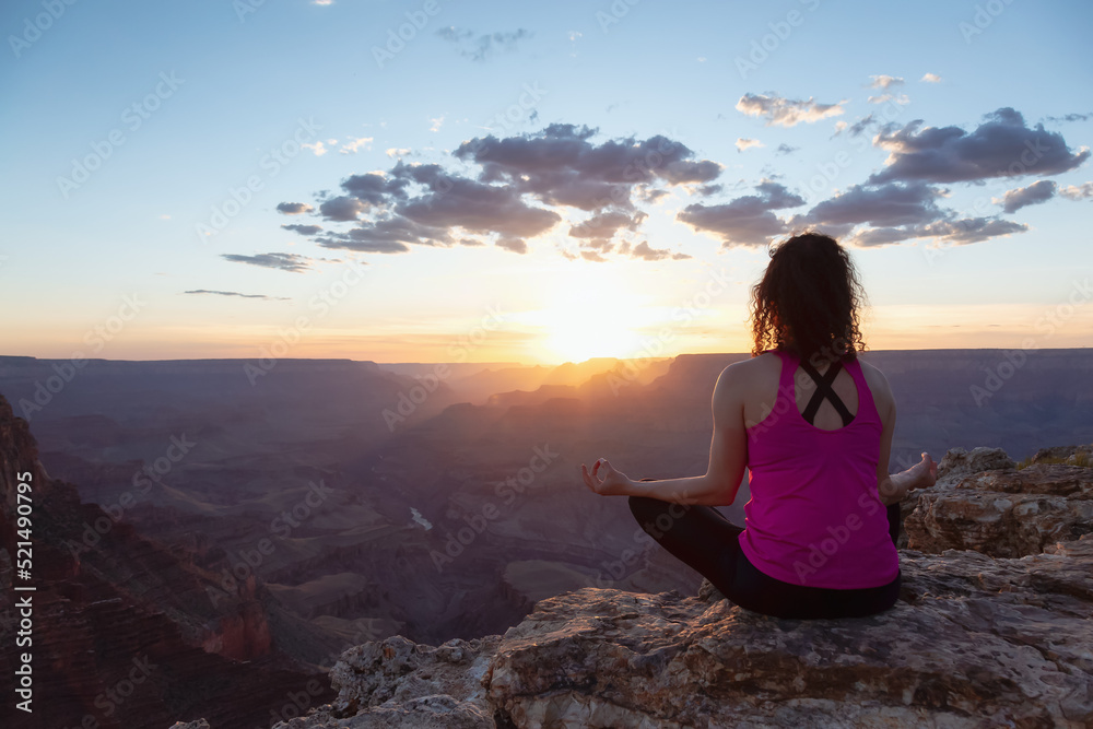 Adventurous Traveler woman doing meditation on Desert Rocky Mountain American Landscape. Cloudy Sunny Sky. Grand Canyon National Park, Arizona, United States. Adventure Travel Adventurous Traveler woman doing meditation on Desert Rocky Mountain American Landscape. Cloudy Sunny Sky. Grand Canyon National Park, Arizona, United States. Adventure Travel