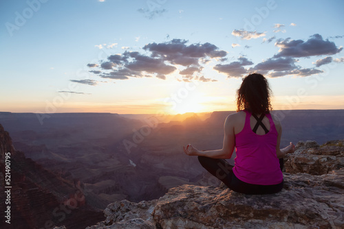 Adventurous Traveler woman doing meditation on Desert Rocky Mountain American Landscape. Cloudy Sunny Sky. Grand Canyon National Park, Arizona, United States. Adventure Travel