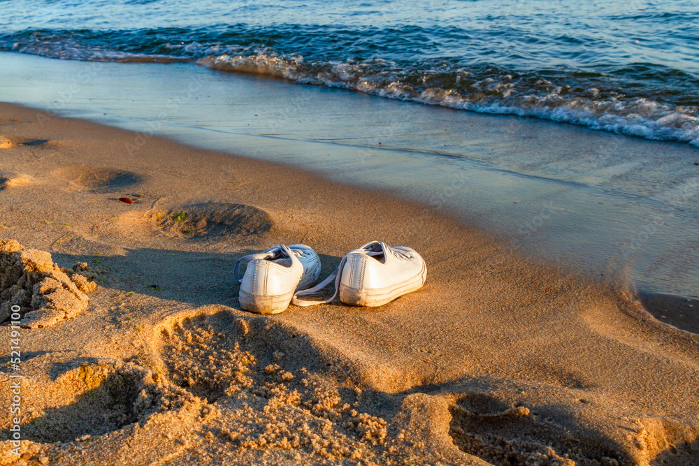 Obraz premium Travel and vacation concept. White sneakers on a sandy beach. Baltic Sea, Hel, Pomerania, Poland