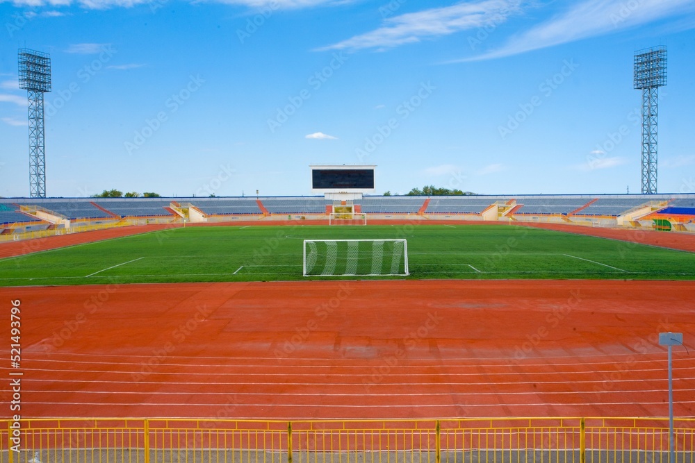 Fototapeta premium STADIUM - Football field with goal and tablo on blue sky