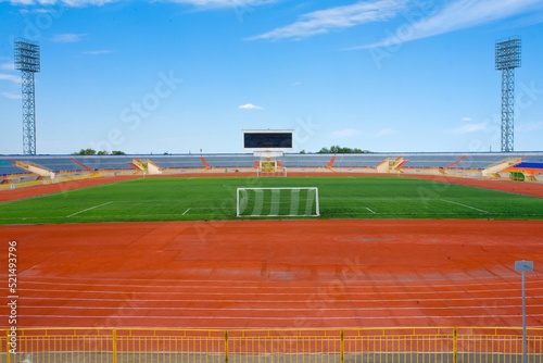 STADIUM - Football field with goal and tablo on blue sky