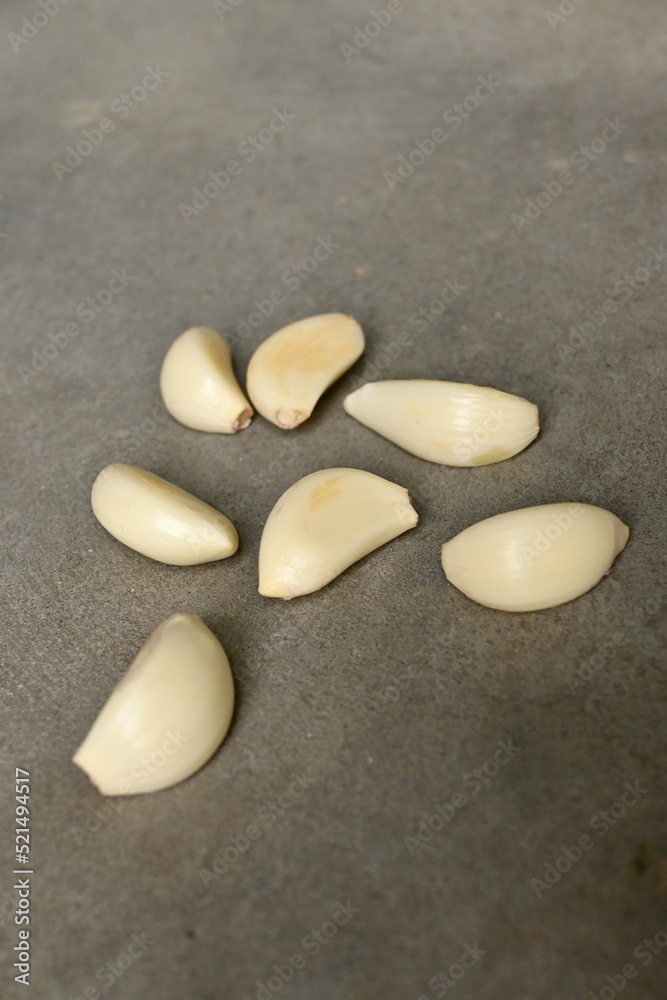 closeup the bunch yellow white peels garlic soft focus natural grey background. closeup the bunch yellow white peels garlic soft focus natural grey background.