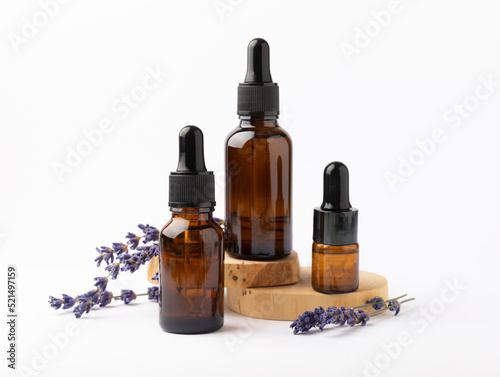 Lavender essential oil in glass bottle with pipette.Bottle with fragrant oil and lavender flowers isolated on white background.mockup of lavender essential oil with copy space.serum.