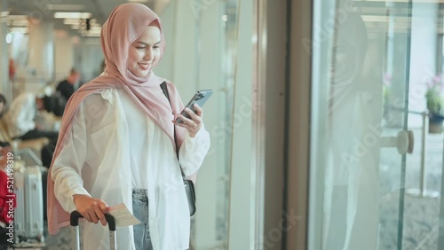 Young female muslim traveler carrying suitcases at the International airport, travel, holidays and journey concept.