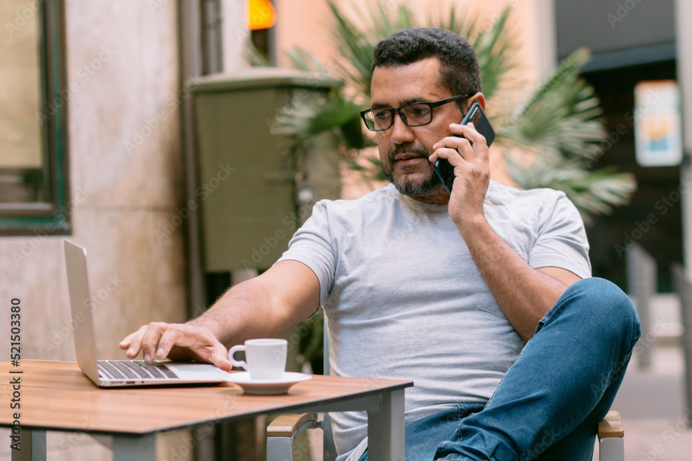 handsome businessman working in cafe and talking with his smartphone handsome businessman working in cafe and talking with his smartphone
