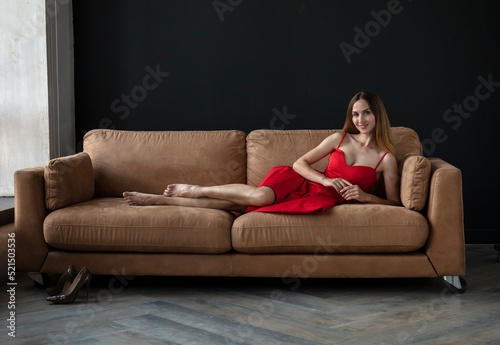 young beautiful woman sitting on a sofa near the window