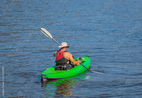 Senior man practicing kayaking. Summer landscape, a man fisherman floats on an inflatable boat on the Cultus lake
