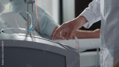 Close up hands female nurse use machine for blood. Man donates blood. Medicine. In hospital room. Healthcare. Slow m otion photo