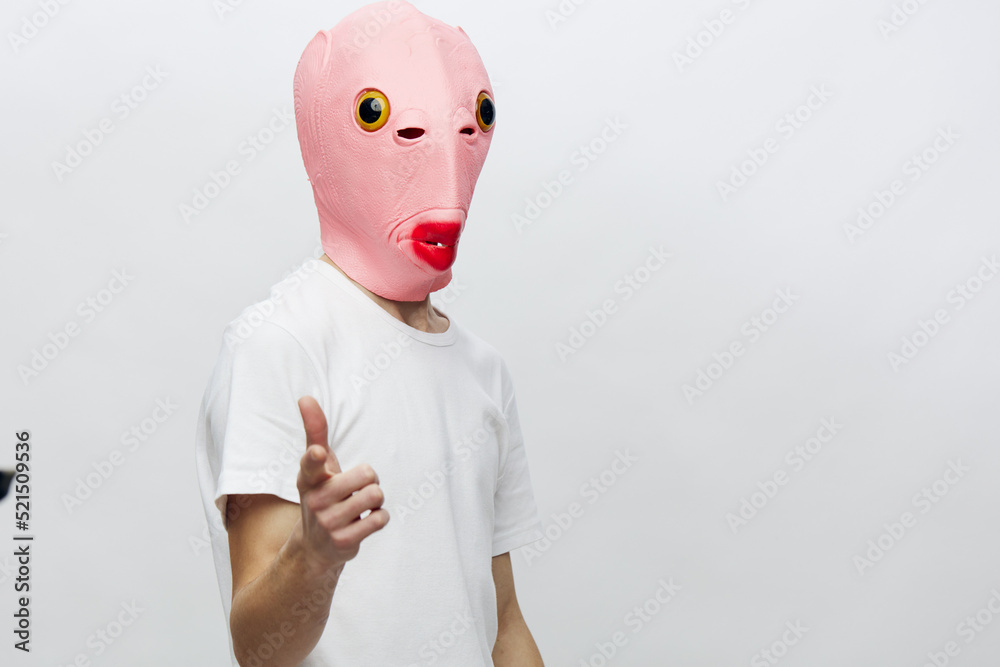 a man in a funny pink mask points his finger at the camera