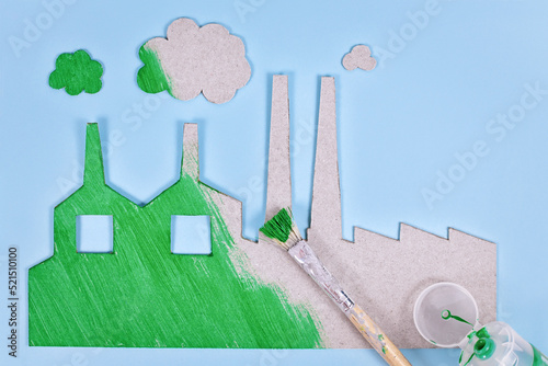 Greenwashing concept with cardboard factory being painted green photo