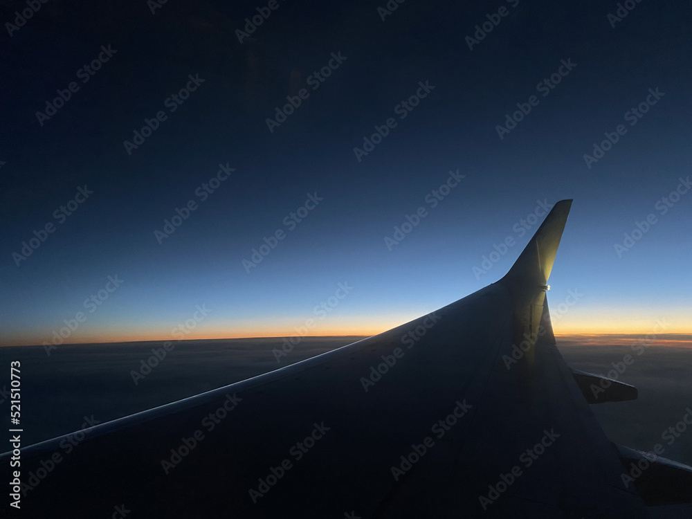 Airplane wing in the sky at sunset. High quality photo
