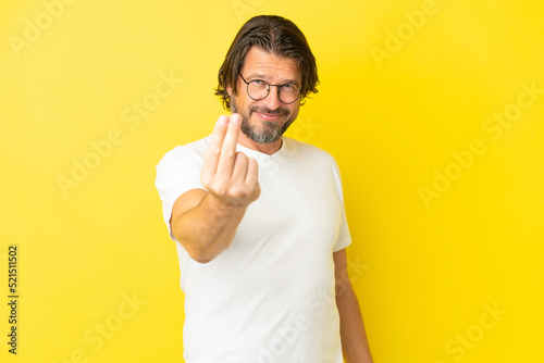 Senior dutch man isolated on yellow background making money gesture