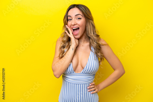 Young caucasian woman isolated on yellow background in swimsuit in summer holidays with surprised expression