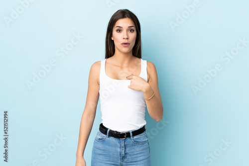 Young caucasian woman isolated on blue background pointing to oneself
