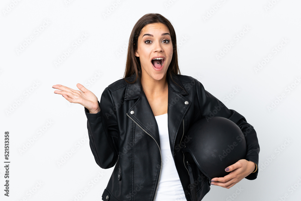 Caucasian girl holding a motorcycle helmet on white background with surprise facial expression Caucasian girl holding a motorcycle helmet on white background with surprise facial expression
