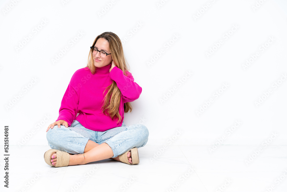 Young caucasian woman sitting on the floor isolated on white background with neckache