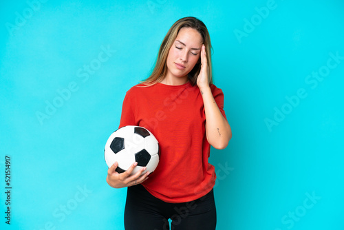 Young football player woman isolated on blue background with headache