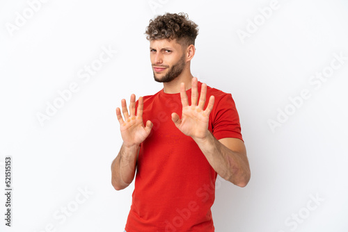 Young caucasian handsome man isolated on white background nervous stretching hands to the front © luismolinero