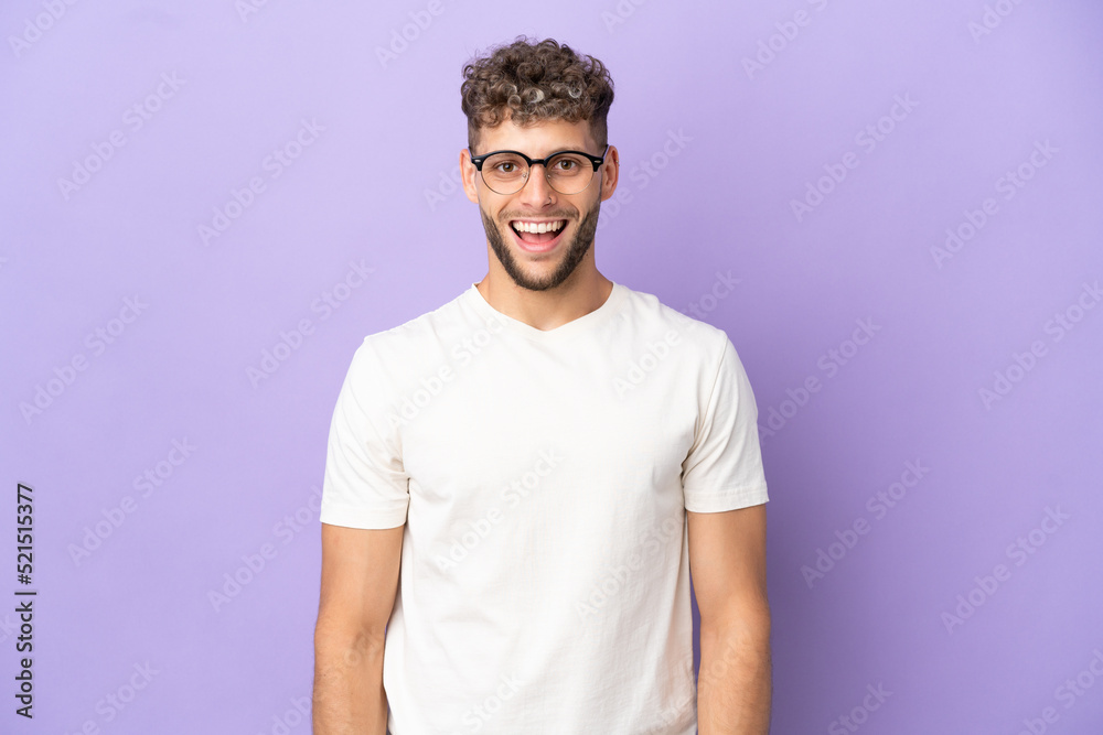 Delivery caucasian man isolated on purple background with surprise facial expression Delivery caucasian man isolated on purple background with surprise facial expression