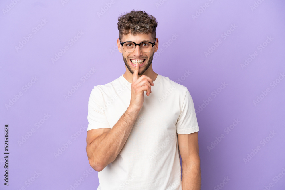 Delivery caucasian man isolated on purple background showing a sign of silence gesture putting finger in mouth