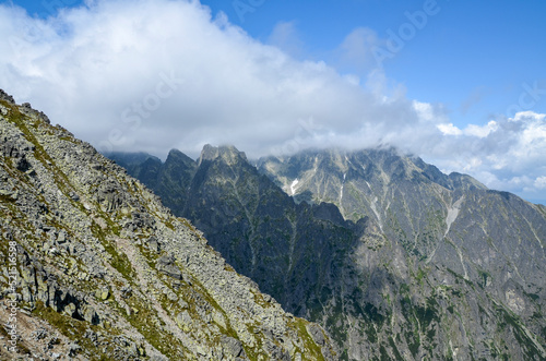 Amazing view of mountain rocky ridge of High Tatras mountains with blue sky and clouds on the peaks. Hiking, trekking and climbing in Slovakia.