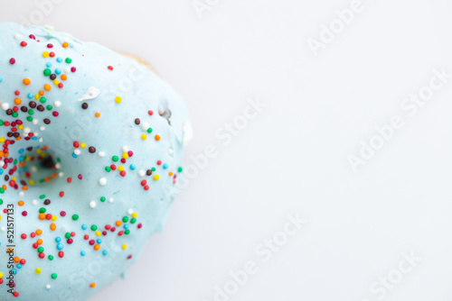 Donuts decorated with colorful sprinkles isolated on white background. Flat lay. Top view
