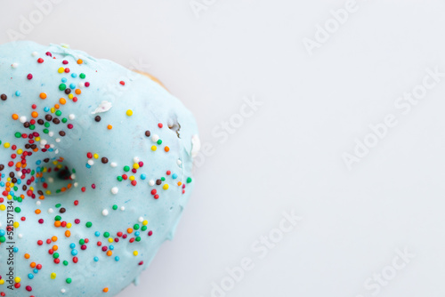 Donuts decorated with colorful sprinkles isolated on white background. Flat lay. Top view
