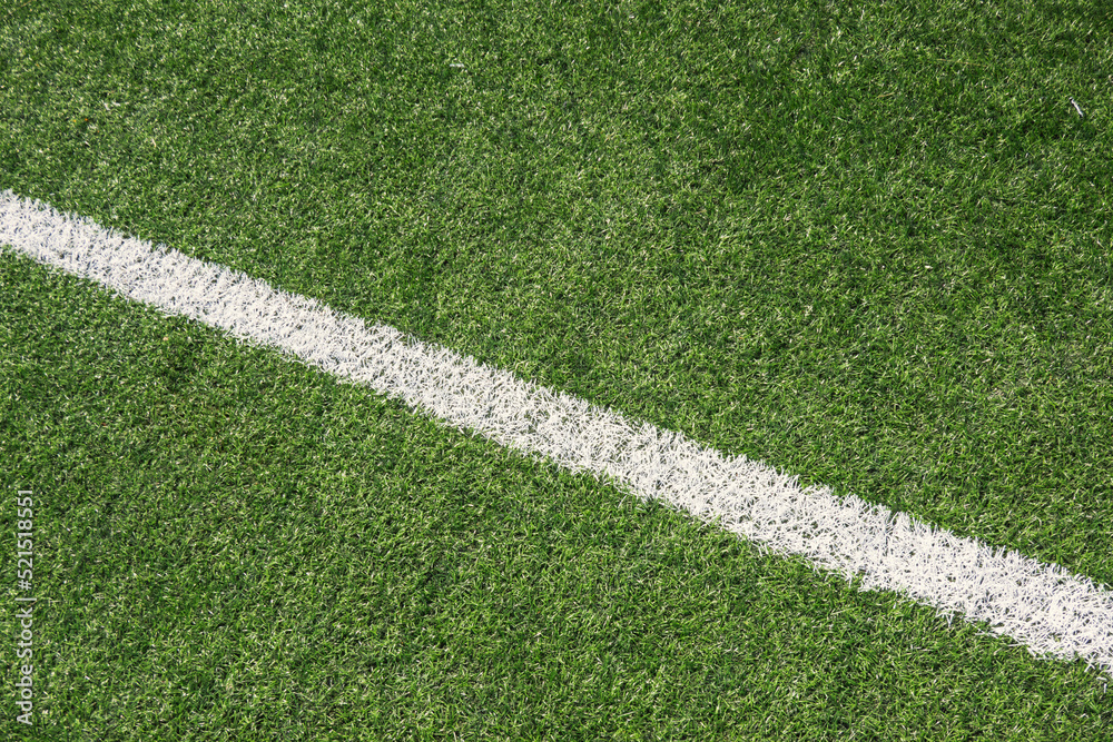 Green synthetic artificial grass soccer sports field with white line