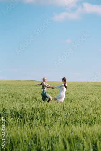 Two Beautiful posing woman in the green field. Fashion, style concept.