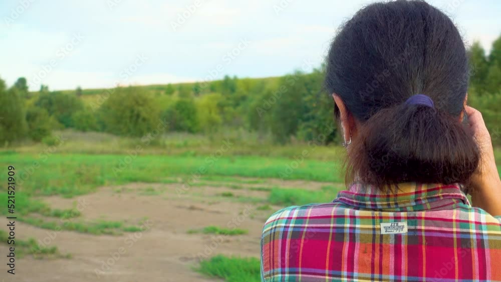 A young woman in a field photographs nature. A girl with a camera walks in nature. Camera movement towards the subject. The concept of happiness, hobby, relaxation. A young woman in a field photographs nature. A girl with a camera walks in nature. Camera movement towards the subject. The concept of happiness, hobby, relaxation.