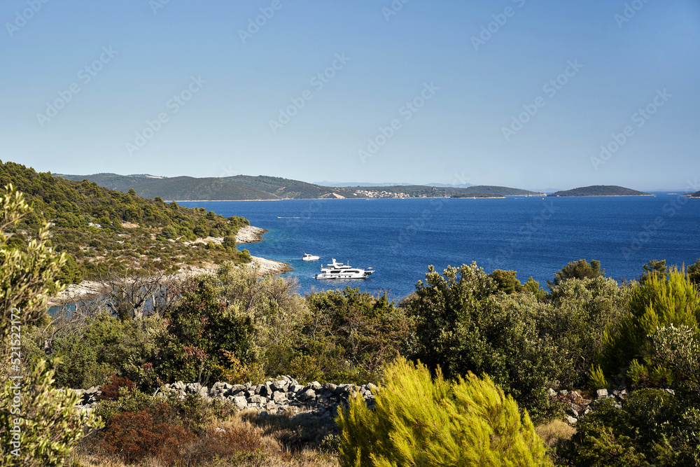 Coast of the Croatian sea with deep blue water. The yacht is moored near the shore