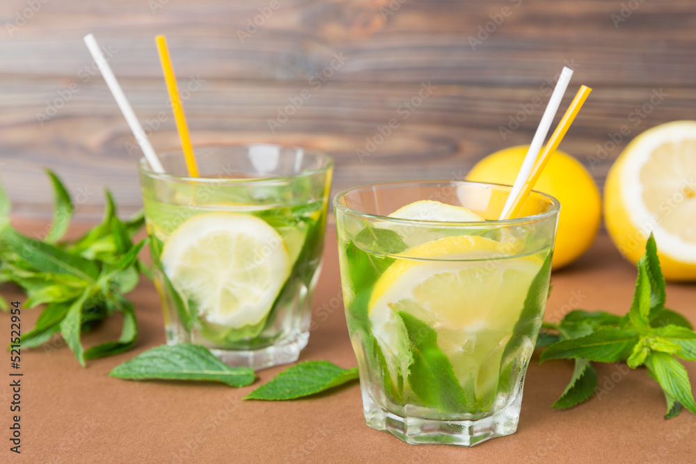 Fototapeta premium Mojito summer refreshing cocktail with ice and mint. mojito cocktail with lime, lemon and mint in a tall glass with a stick