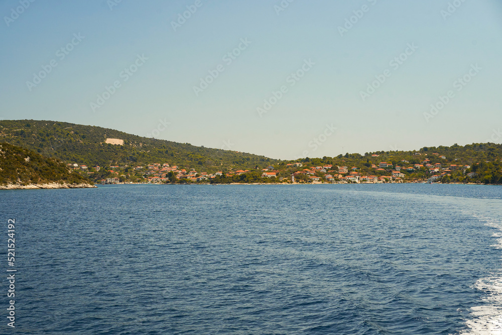 The coast of the Croatian sea with clear water and the setting sun.