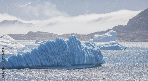 landscape of large icebergs and mountains in Prince Christian Sound, South Greenland photo