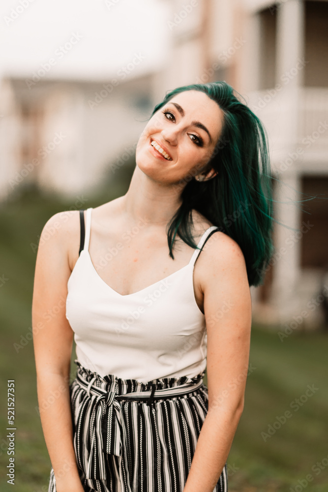 Girl with green hair sitting in the grass