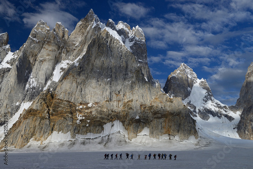 A group of trekkers crossing Biafo Glacier and heading towards Hispar Pass while crossing Solu Towers (5947m) in the vicinity of Snow Lake and Hispar La in Pakistan photo