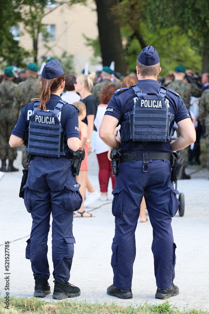 Polska Policja na służbie w czasie patrolu na mieście. - obrazy, fototapety, plakaty 