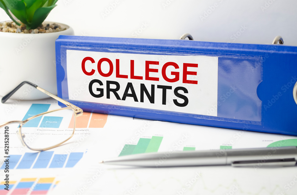 The word college GRANTS is written on a blue file folder next to documents