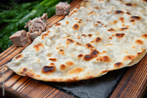 Azerbaijani Kutab with veal on a wooden board. selective focus photo