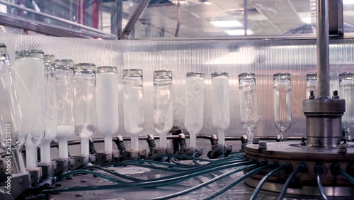 Complex for the production of glass bottles and drinks. Clip. Mechanical machine in a factory with the manufacture of glass containers and liquids.