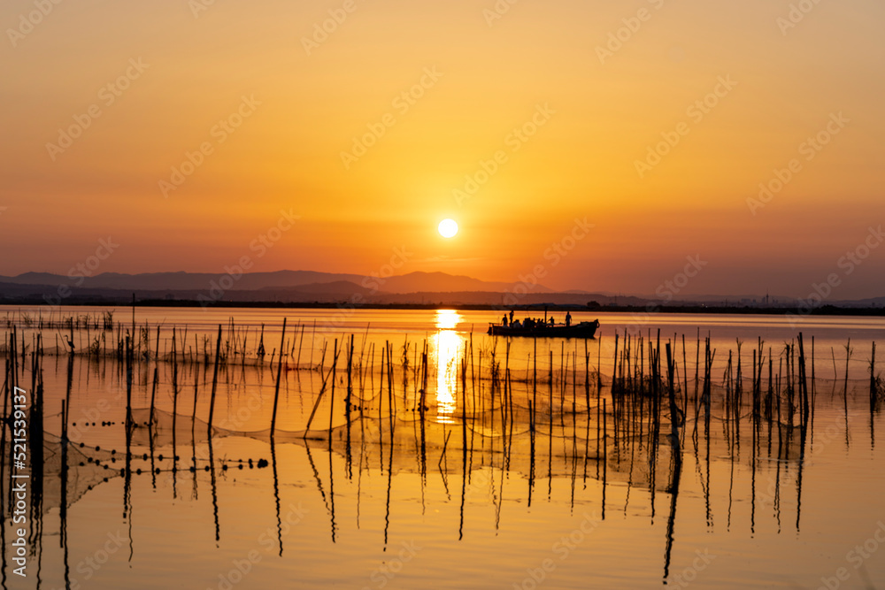 Couché de soleil en Espagne avec des filets de pêche, orangé avec bateau