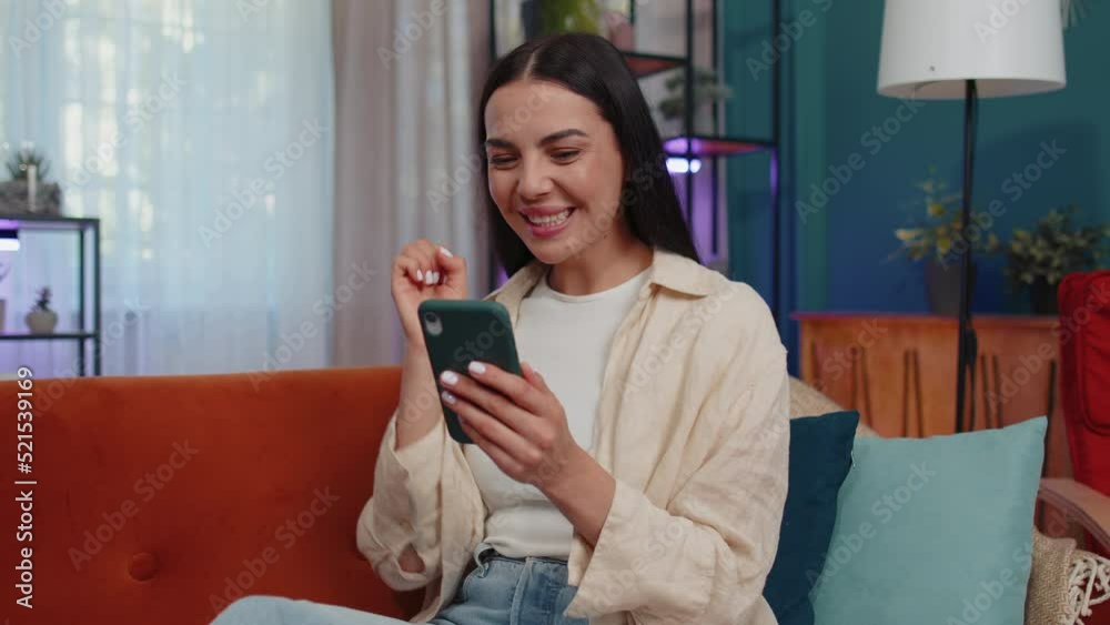 Oh my God Wow. Excited happy joyful winner girl use smartphone typing browsing found out great win good news celebrate victory. Young woman with mobile phone lying at home in room on orange couch Oh my God Wow. Excited happy joyful winner girl use smartphone typing browsing found out great win good news celebrate victory. Young woman with mobile phone lying at home in room on orange couch
