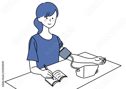 血圧を計り記録する女性