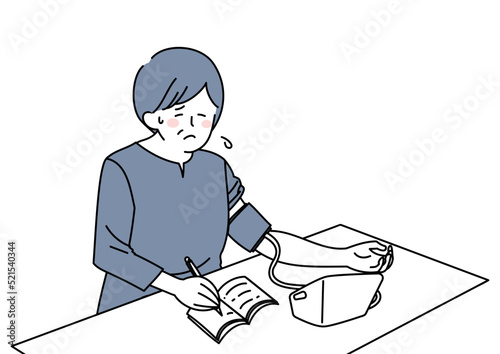 血圧を計り記録する女性