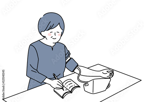 血圧を計り記録する女性