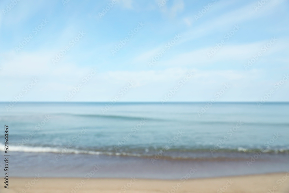 Blurred view of sea shore under blue sky on sunny day