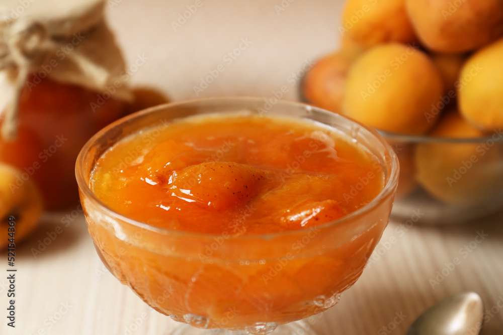 Dessert bowl with delicious apricot jam on white wooden table, closeup Dessert bowl with delicious apricot jam on white wooden table, closeup