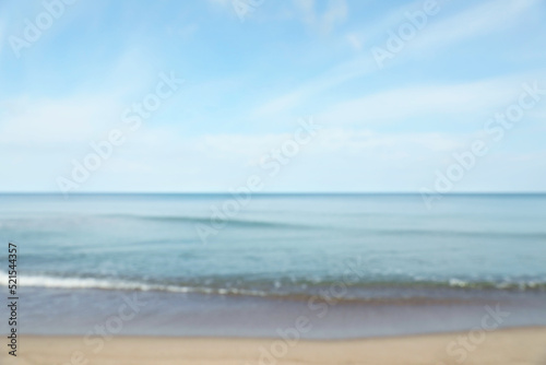 Fototapeta Naklejka Na Ścianę i Meble -  Blurred view of sea shore under blue sky on sunny day